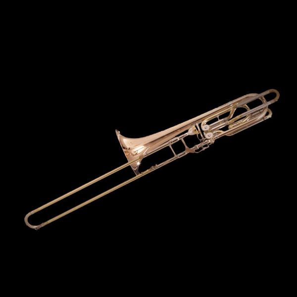 Bass trombone in Bb/F on a black background, showcasing the brass instrument's detailed slide and valves for orchestral music or jazz performance.