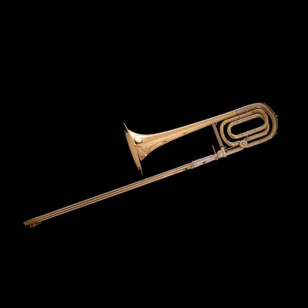 Golden tenor trombone in Bb, a brass musical instrument, on a black background.