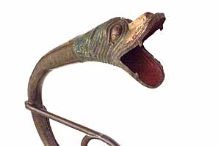 Detail of a tenor trombone's waterslide decorated with a carved dragon's head.
